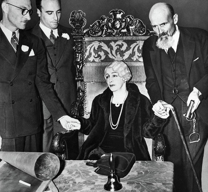Picture of woman seated at table, surrounded by 3 men